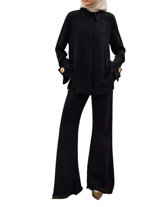 Silhouette de face, chemise noire portée avec pantalon assorti.