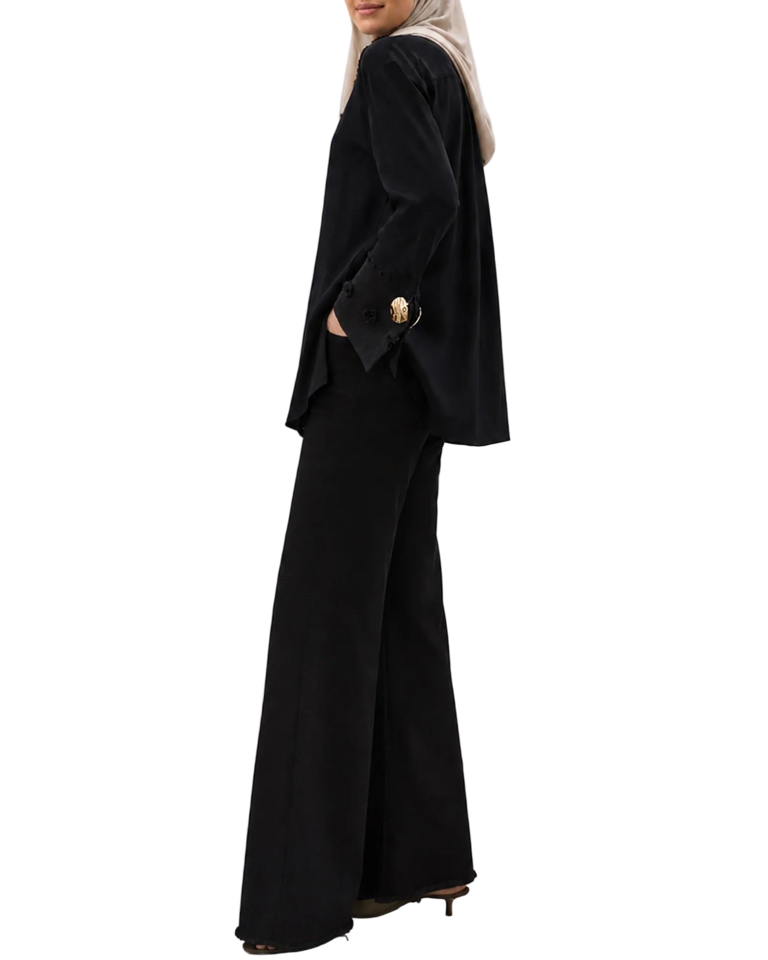 Vue de profil d'une chemise noire élégante, coupe moderne et pudiq
